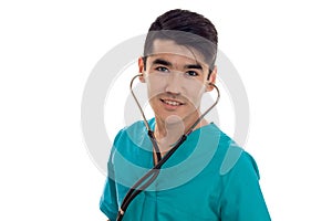 Cheerful elegant doctor in blue uniform with stethoscope posing and smiling on camera isolated on white background