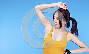 Cheerful elegant woman showing her armpit clean clear depilation while standing on blue background. Perfect skin armpit