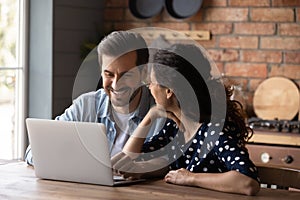 Cheerful emotional young family couple using computer.