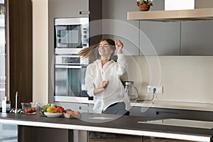 Cheerful energetic chef girl enjoying cooking healthy meal in kitchen