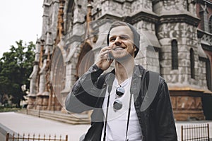 Cheerful and energetic traveller is standing at the corner of the street