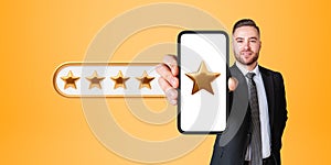 Cheerful European man showing smartphone with five star rating