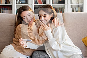 Cheerful european millennial lady hugs and congratulate surprised happy girlfriend with pregnancy