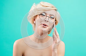 Cheerful, excited blonde talking on the phone while taking a bath