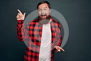 Cheerful excited guy spot interesting promo and share with us. Smiling handsome man pointing sideways as shopping in store with