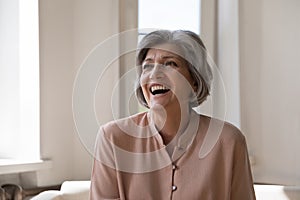 Cheerful excited mature woman looking away, laughing