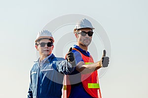 Cheerful factory worker and engineer man smiling with giving thumbs up as sign of Success