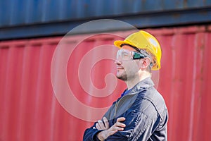 Cheerful factory worker man in hard hat smiling with arms crossed as sign of Success