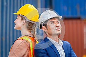 Cheerful factory worker team in hard hat smiling with arms crossed at cargo containers