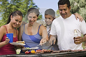 Feliz familia alrededor parrilla sobre el 