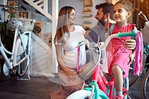 Cheerful family buying new bicycle for little girl in bike shop
