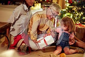 Cheerful family for Christmas in front of a decorated x-mas tree.grandmather  and little girl together for Christmas