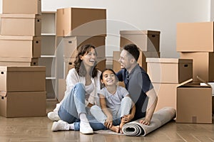 Cheerful family couple and little kid moving into new apartment
