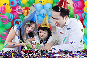 Cheerful family cutting a birthday cake