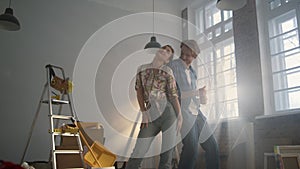 Cheerful family enjoying home repair indoors. Joyful couple dancing inside.