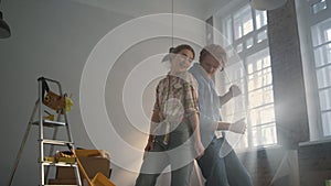 Cheerful family enjoying home repair indoors. Joyful couple dancing inside.