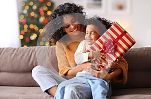 Cheerful family: happy child and mother congratulate each other at Christmas