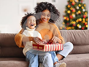 Cheerful family: happy child and mother congratulate each other at Christmas