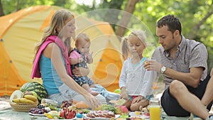 Cheerful family having picnic with fruits