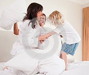 Cheerful family having pillow fight