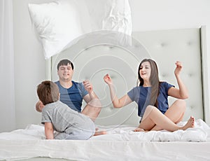 Cheerful family having pillow fight in a bedroom