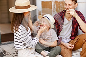 Cheerful family is having a rest and having fun on the porch of a country house