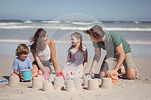 Cheerful family making sand castle at beach