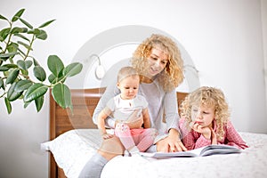 Cheerful family mother reading to children book