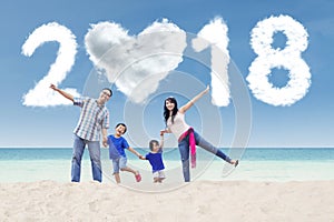 Cheerful family with numbers 2018 at shore