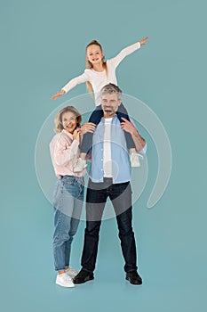 Cheerful Family Posing Together Smiling To Camera, Blue Background, Vertical