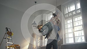 Cheerful family rejoicing indoors. Happy couple having fun in new house.