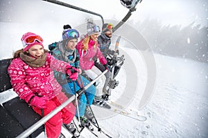 Family in ski lift going to ski terrain