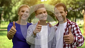 Cheerful family smiling showing thumbs-up, lucrative loans, credits for studying