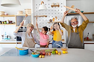 Cheerful family spending good time together while cooking in kitchen