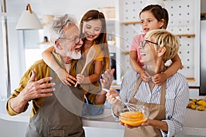 Cheerful family spending good time together while cooking in kitchen