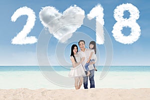 Cheerful family standing under numbers 2018