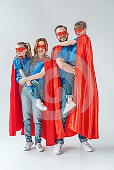 cheerful family of superheroes smiling at camera