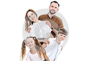 cheerful family with two children standing together and smiling at camera