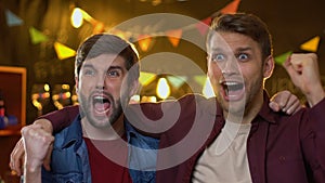 Cheerful fan friends watching sport championship in bar, celebrating team goal