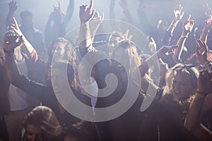 Cheerful fans dancing at nightclub during music festival