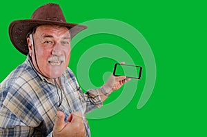 Cheerful farmer advertises telemedicine services holding a smartphone with a green screen.