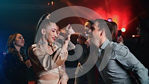 Cheerful fashion couple pair fun joy dancing together at party dance floor discotheque nightclub