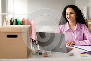 Cheerful Fashion Dressmaker Woman Using Laptop Working In Online Store