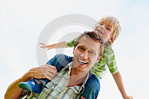 Cheerful father carrying his son on shoulder against white. Portrait of a smiling father carrying his son on shoulder