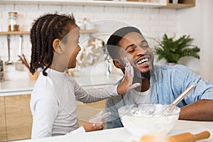 Cheerful father and daughter having fun while cooking