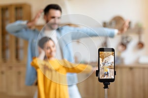 Cheerful Father And Daughter Shooting Dance Video On Cellphone Indoors