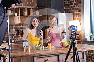 Cheerful female bloggers recording a video
