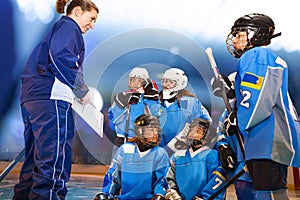 Female coach showing game plan to ice hockey team photo