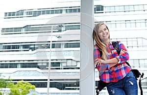 Cheerful female college student standing outside