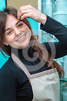 Cheerful female cosmetologist in an apron